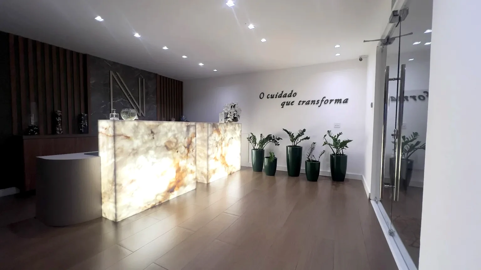 Recepção do NV Health Institute, com balcão iluminado e identidade visual NV